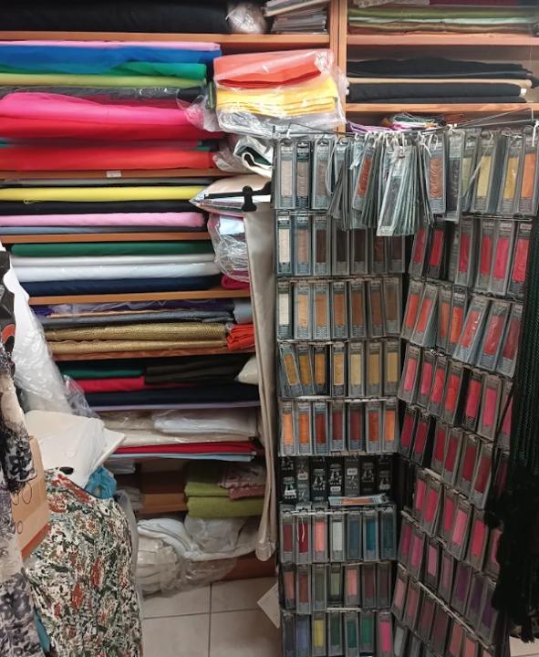 Pile di tessuti colorati ed espositore di fili da ricamo